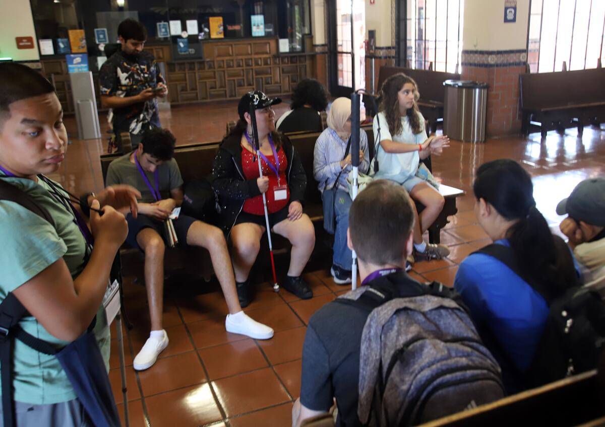 Teens and young adults with visual impairment and other disabilities wait for the Amtrak train.