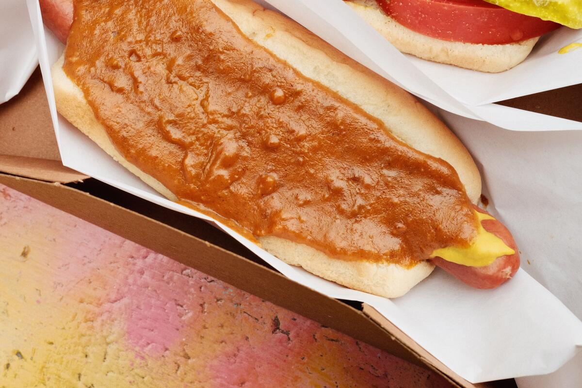 A signature Cupid dog with chili, mustard and onions in a cardboard box at Cupid's Hot Dogs in Winnetka.