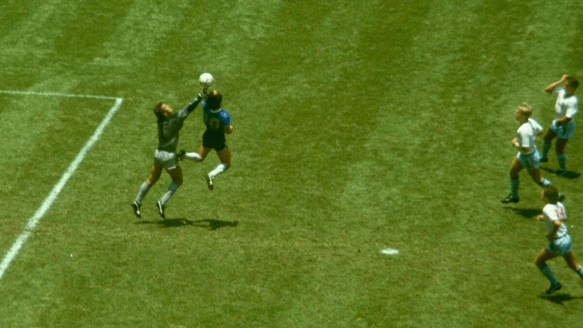 Argentina player Diego Maradona outjumps England goalkeeper Peter Shilton to score with his 'Hand of God'