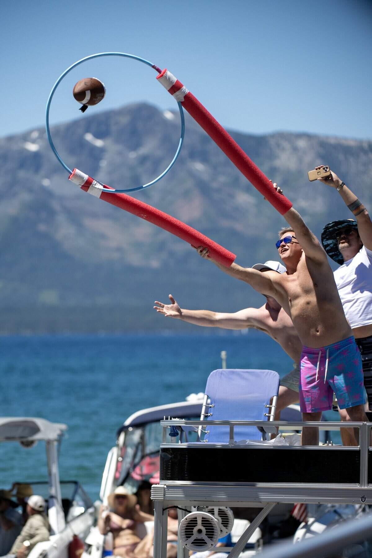 Fans engage with celebrity golfers as they get their football autographed and returned on the 17 tee during the American Century Championship at Edgewood Tahoe Golf Course in Stateline, Nev., on Friday, July 10.