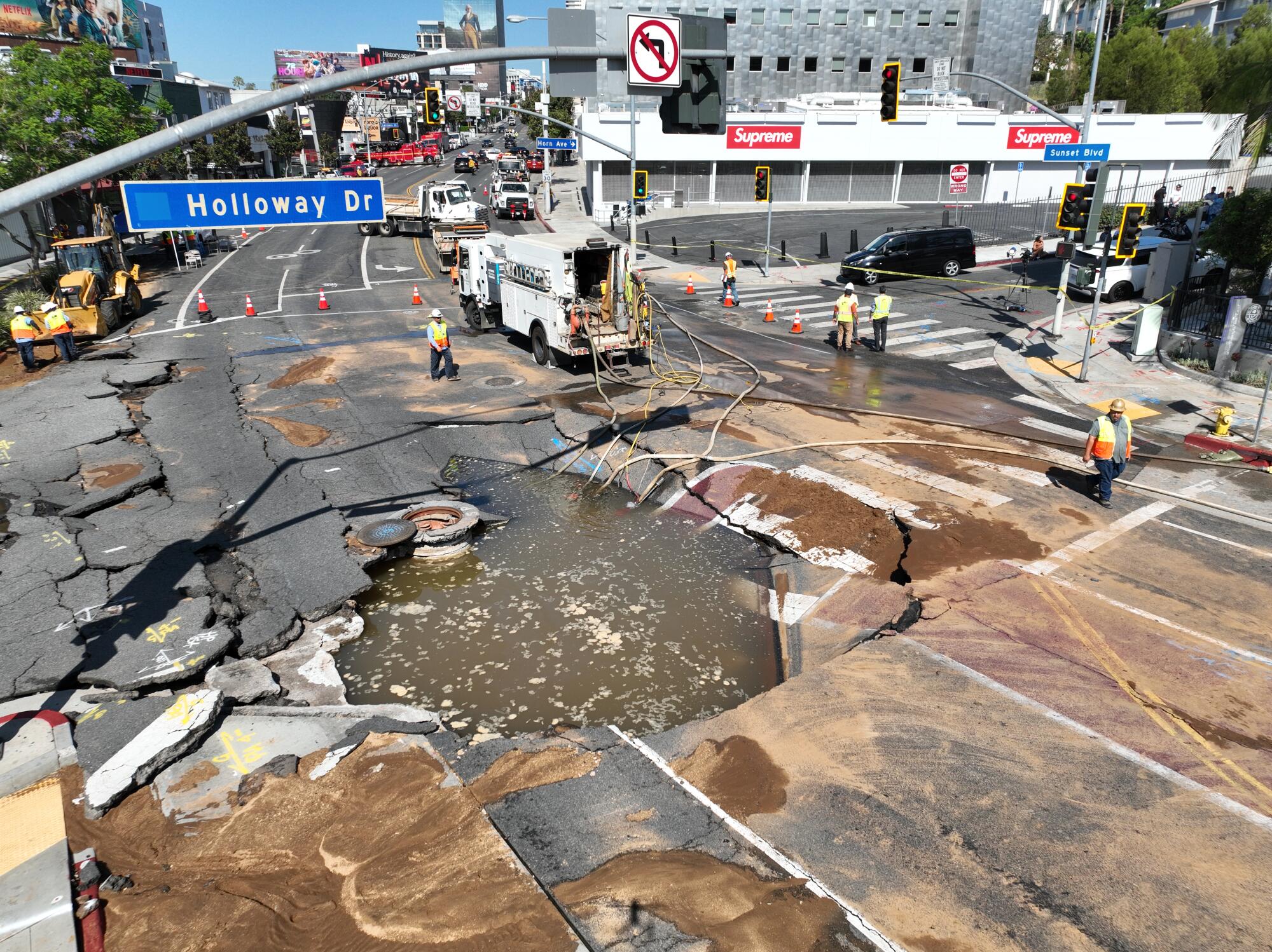An aerial view of workers viewing a broken water main at Sunset and Holloway.