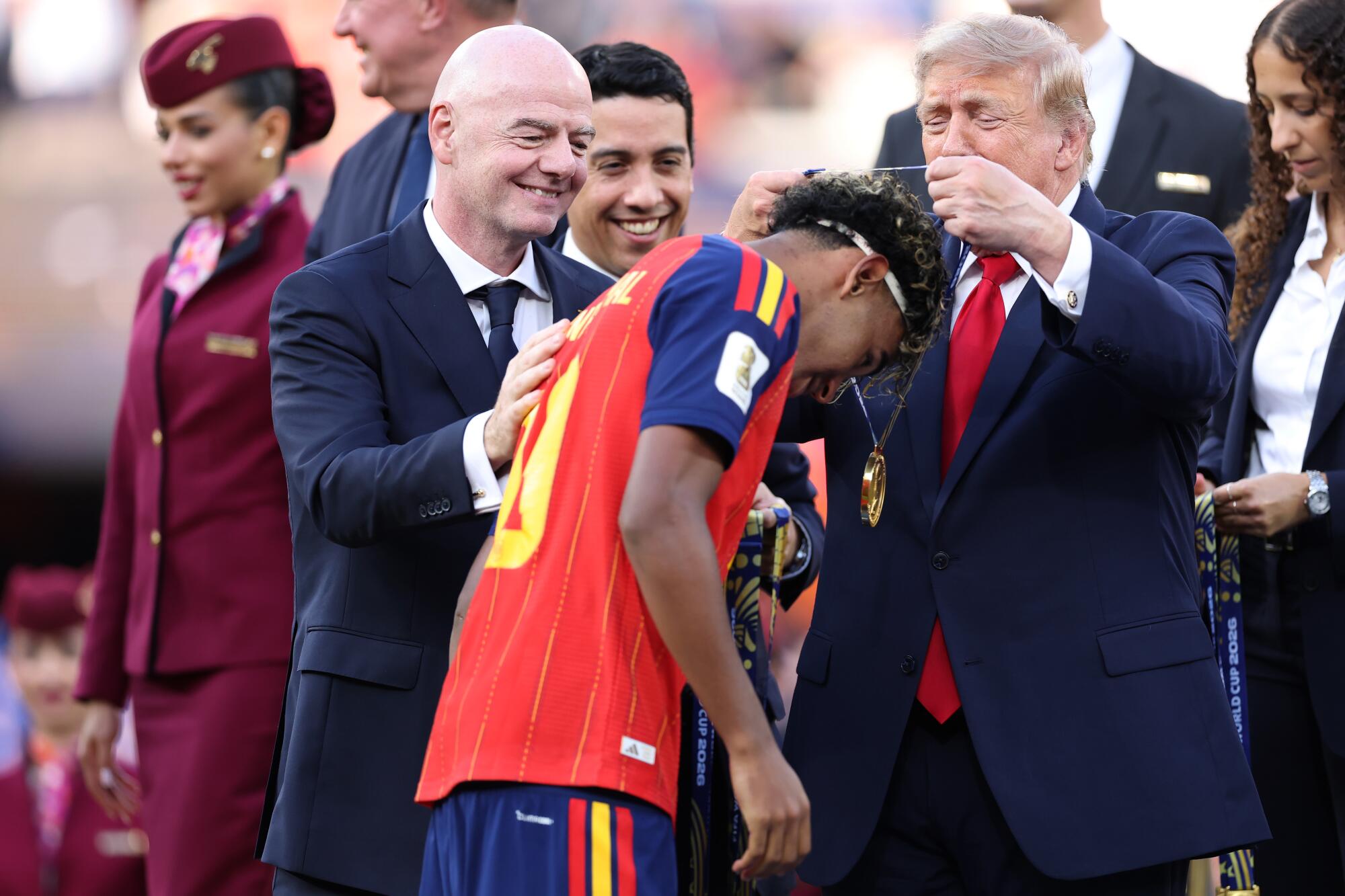 Spain star Lamine Yamal is congratulated by FIFA President Gianni Infantino, left, and President Trump.