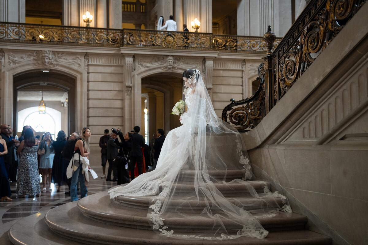 Shuting Zang, 28, sits while being photographed on her wedding day at San Francisco City Hall 