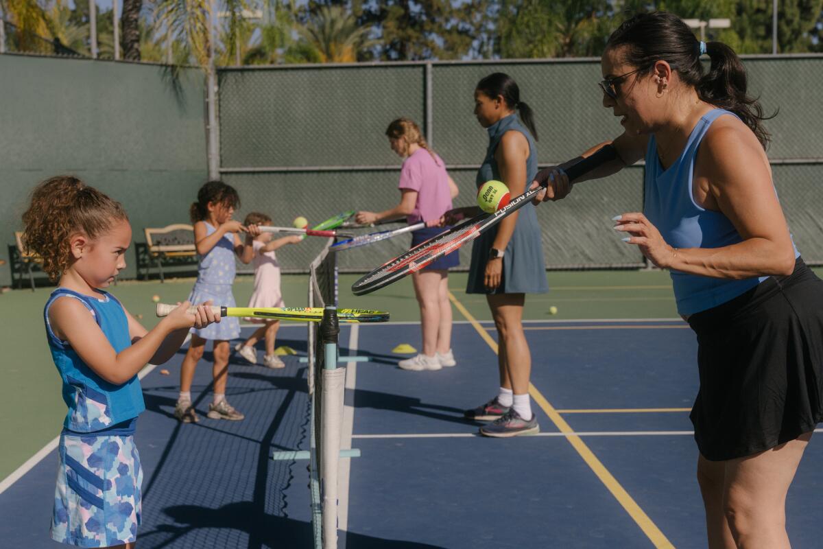 A mom runs tennis drills with her daughter during a Mommy & Me tennis class at Burbank Tennis Club 