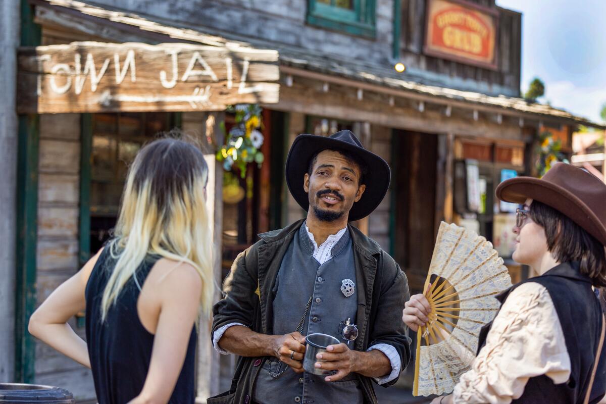 Visitors talk to Evan Battle, center, who plays Deputy Chester Davenport.