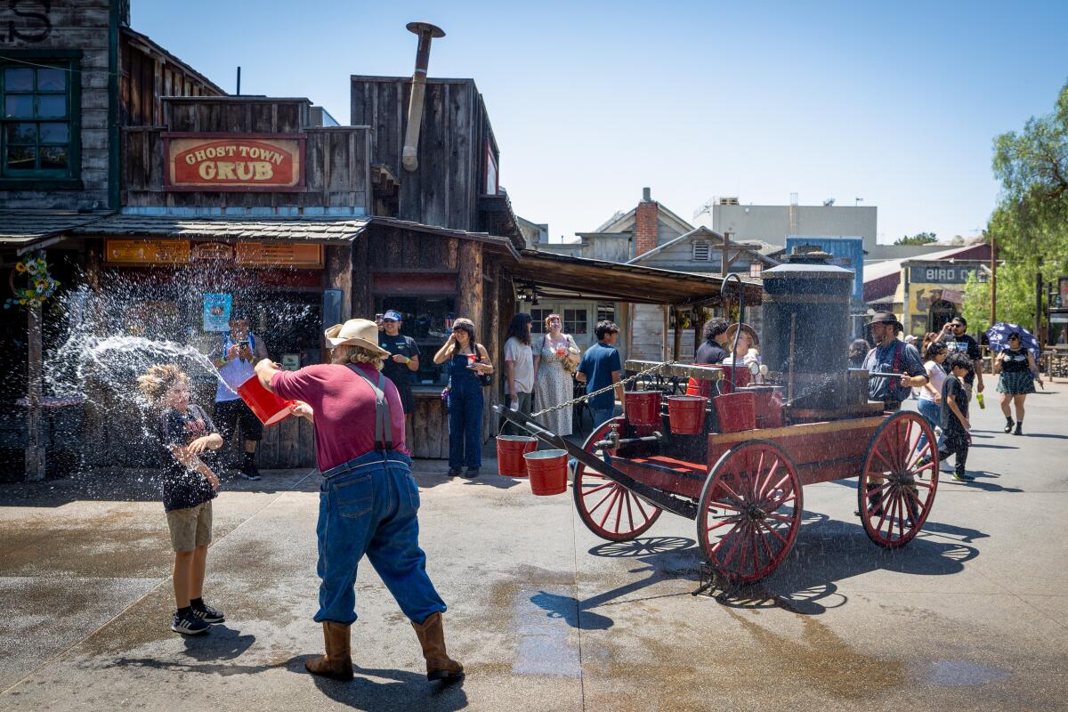Dustin Kennedy, performing as Flint Staholkof, soaks visitors with water.