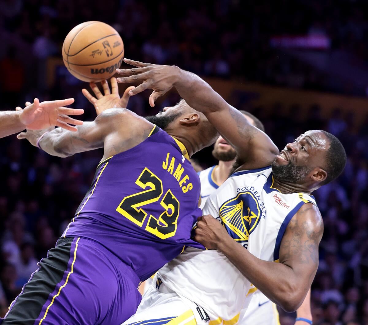 Lakers forward LeBron James, left, tries to score against Warriors forward Draymond Green, who pulls James' jersey.