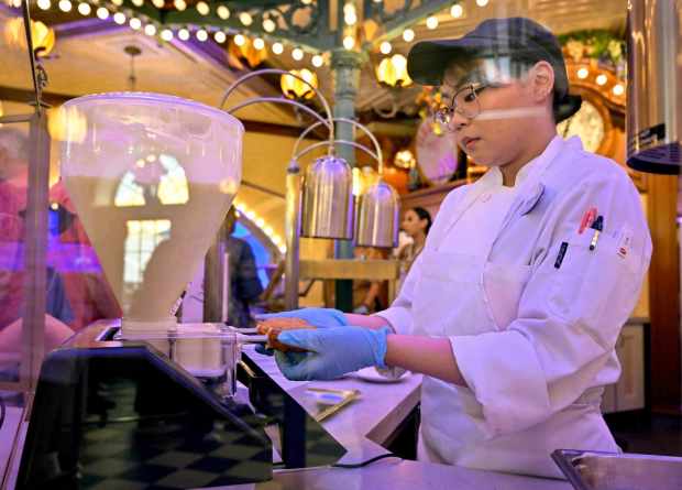 A cook fills a beignet at the new Tiana's Palace restaurant in New Orleans Square inside Disneyland in Anaheim, CA, on Wednesday, September 6, 2023. The Creole and Cajun-inspired restaurant replaces the French Market Restaurant that has been in the land since 1966. (Photo by Jeff Gritchen, Orange County Register/SCNG)