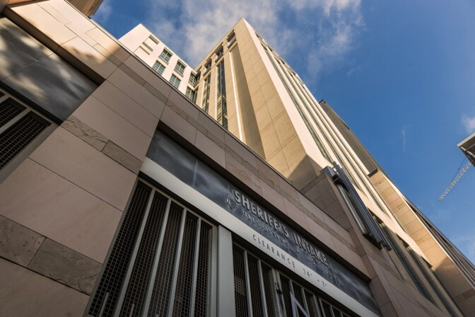 A tall, multi-story brown building with signage on the front that reads "sheriff intake."