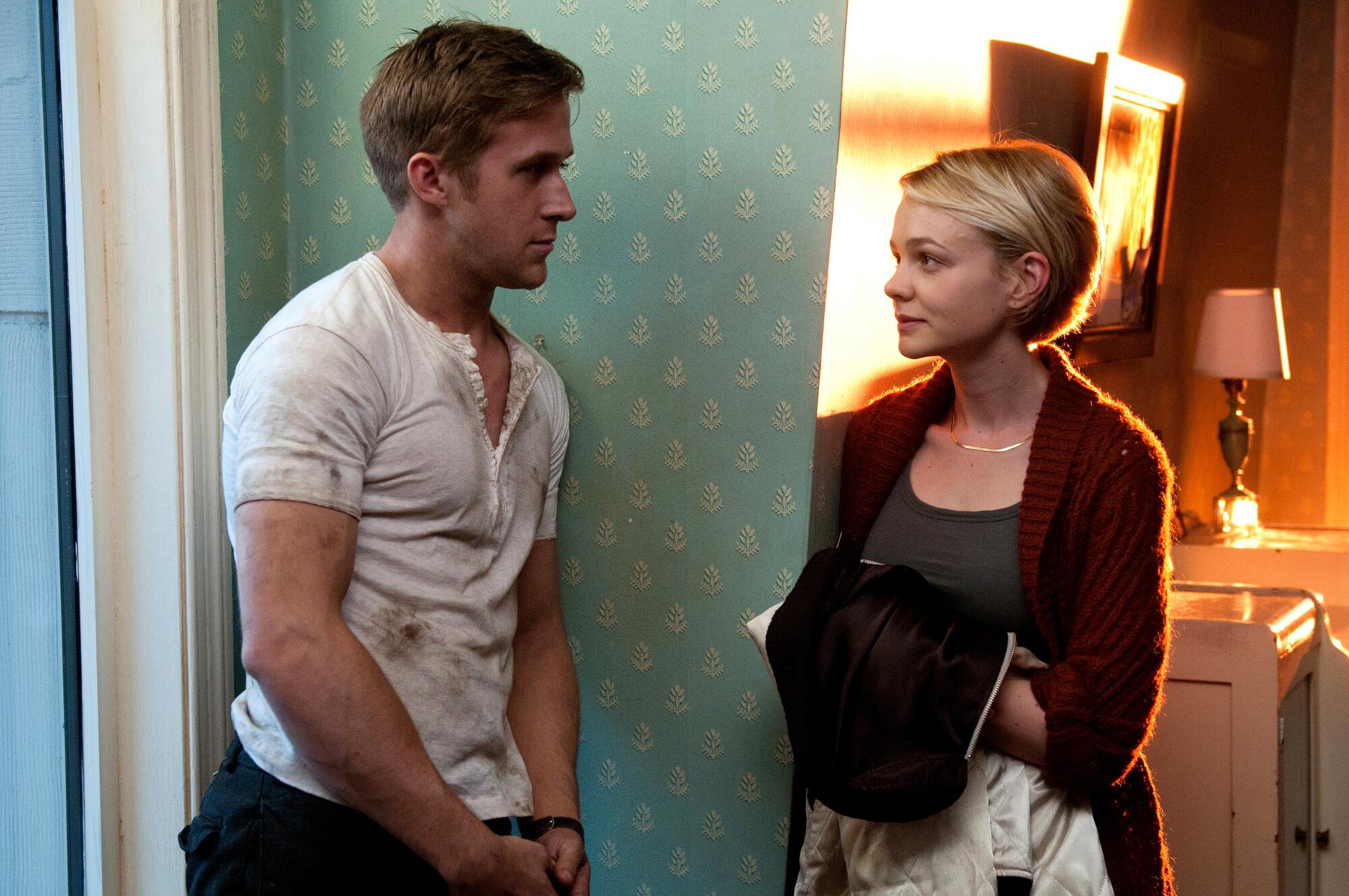 A man and a woman flirt in a wallpapered apartment.
