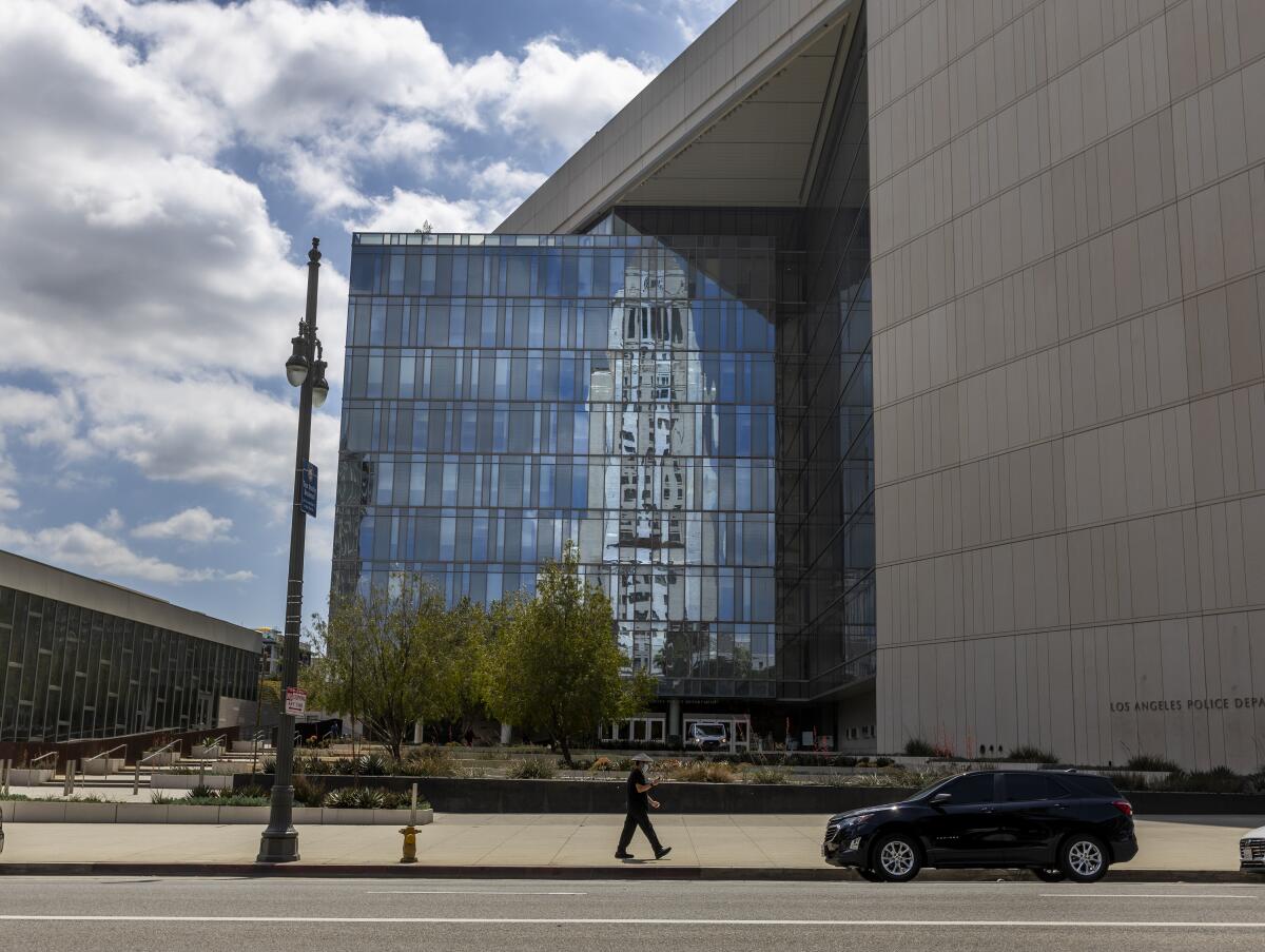 Los Angeles City Hall is reflected in the windows of the Los Angeles Police Headquarters.