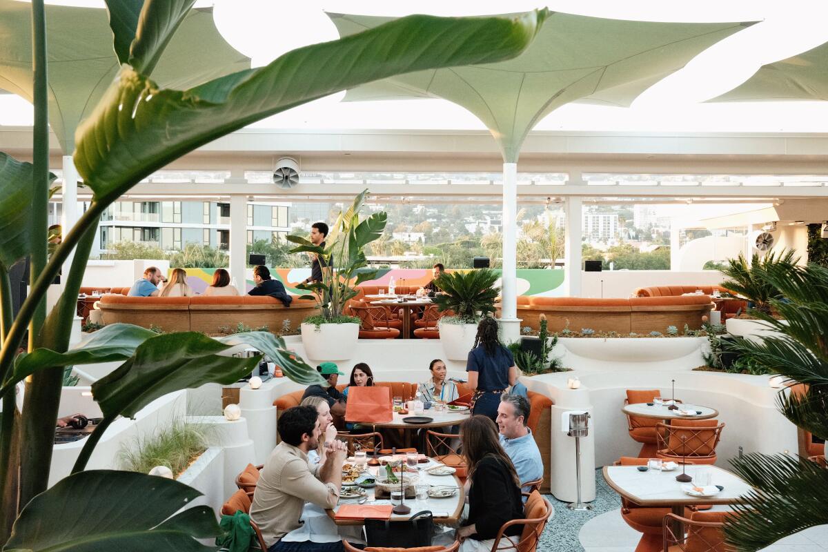 Guests dine on the green-and-white rooftop bar and restaurant Sushi Samba in West Hollywood