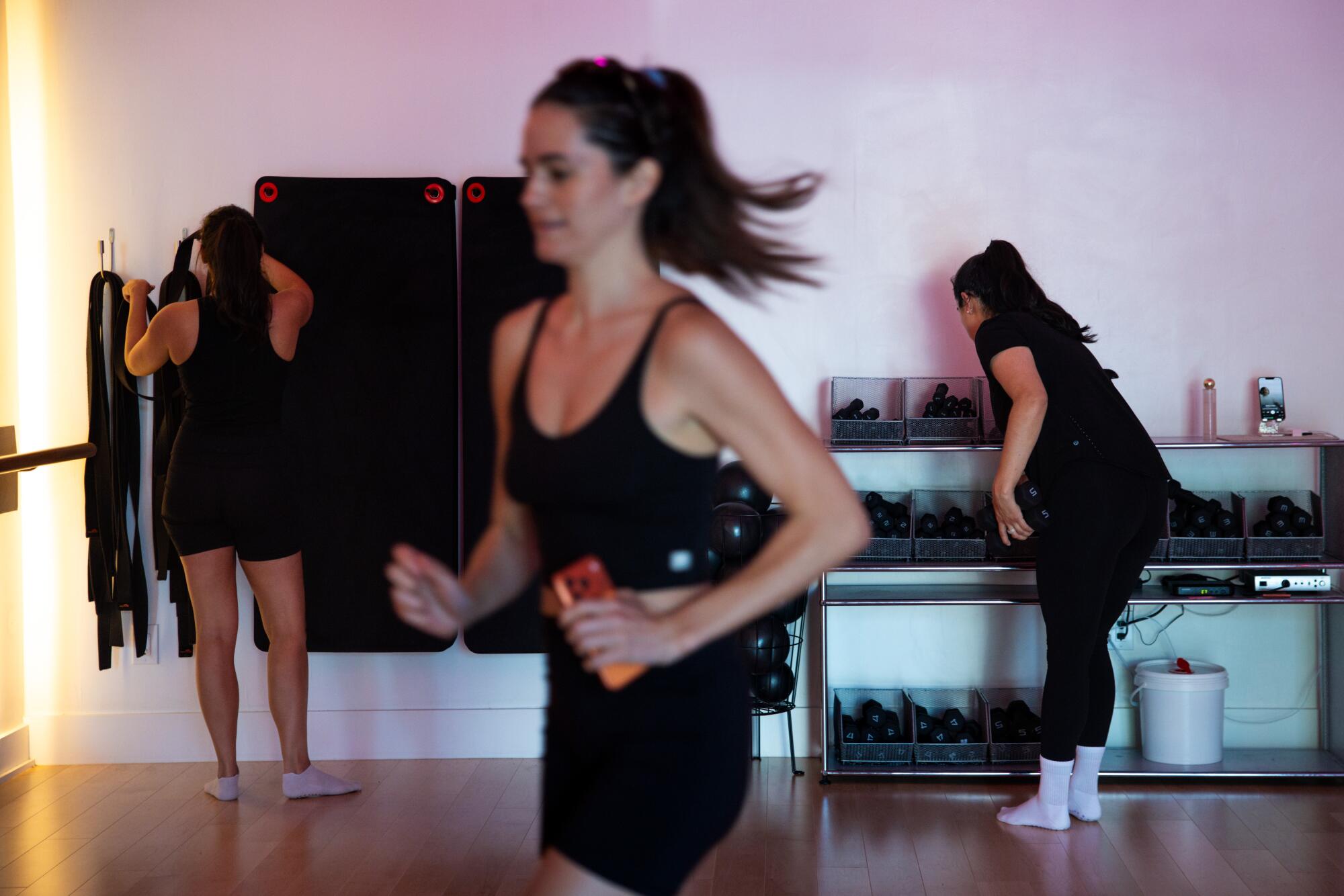 A woman puts away her mat post-workout.