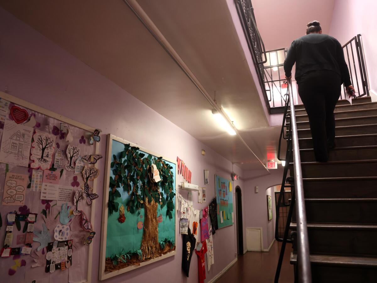 A person makes her way upstairs where each family fleeing domestic violence has their own separate living quarters.