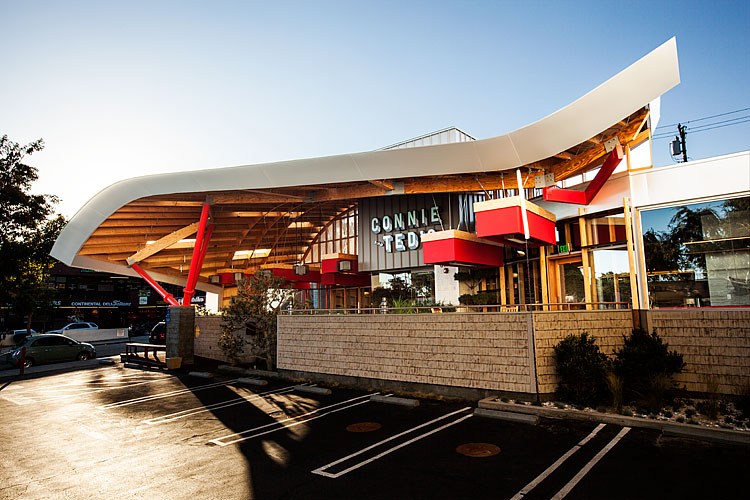 A white, tan, and red building that houses Connie & Ted’s restaurant in West Hollywood, California.