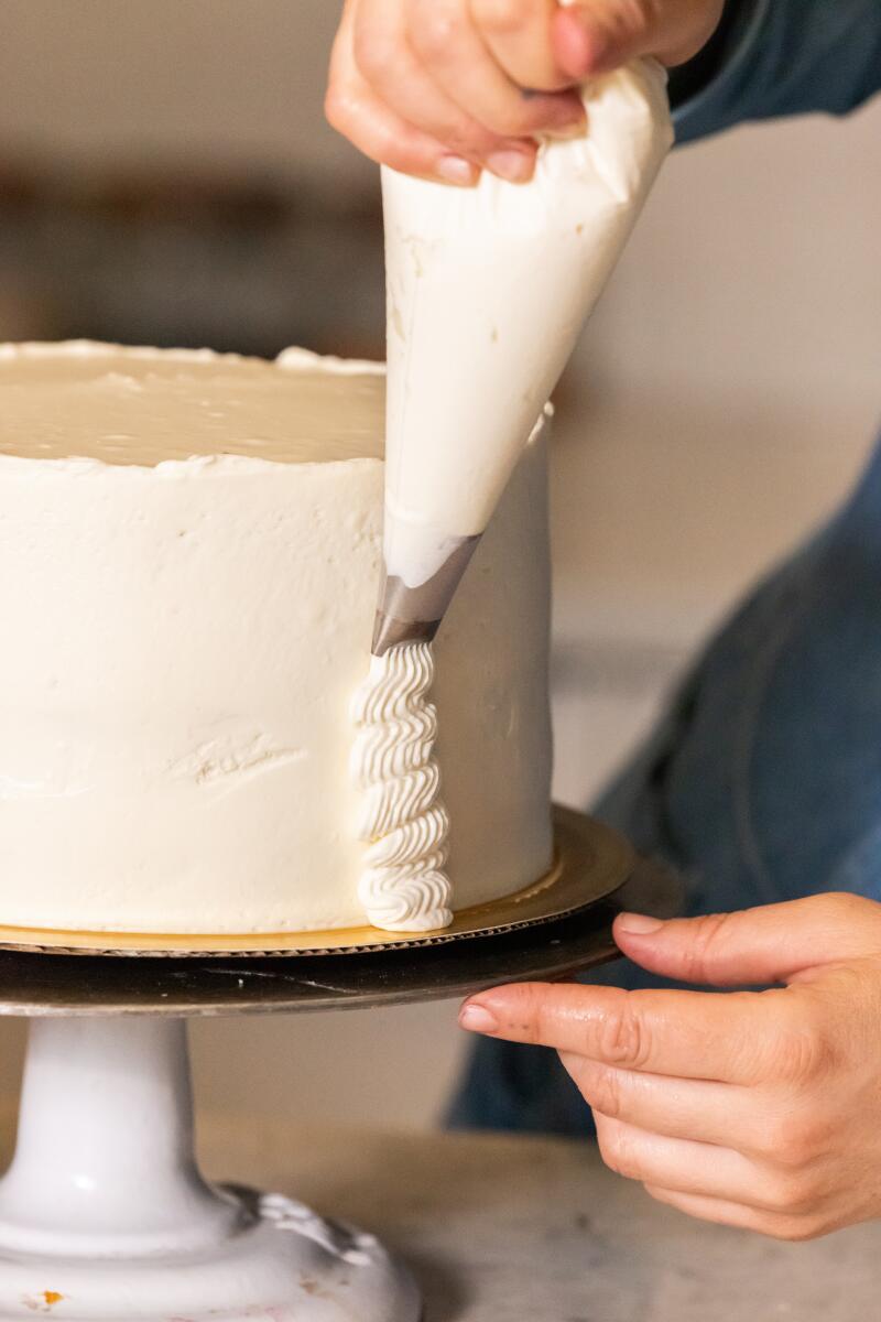 El SEGUNDO, CA -- JULY 15, 2026: Rose Wilde decorating The Ultimate Birthday Cake, recipe by Carolynn Carreno, photographed in the Los Angeles Times Kitchen in El Segundo, CA on Wednesday, July 15, 2026. (Catherine Dzilenski / For The Times)