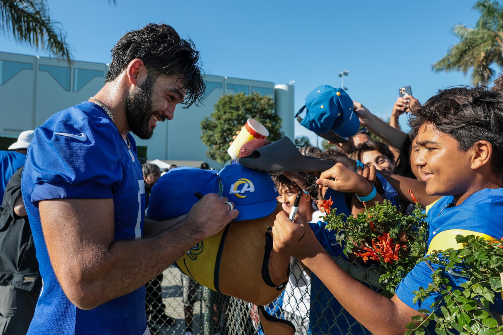 Rams receiver Puka Nacua signs autographs during training camp at Loyola Marymount University on Sunday.