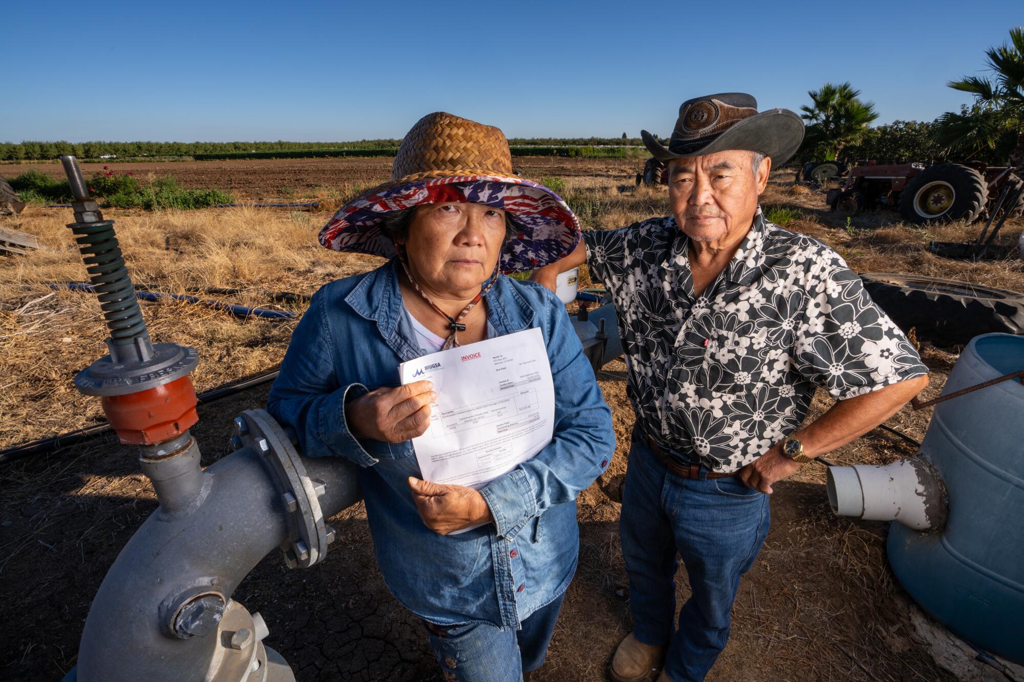 Rosie Lee and Charlie Moua stand in a field.