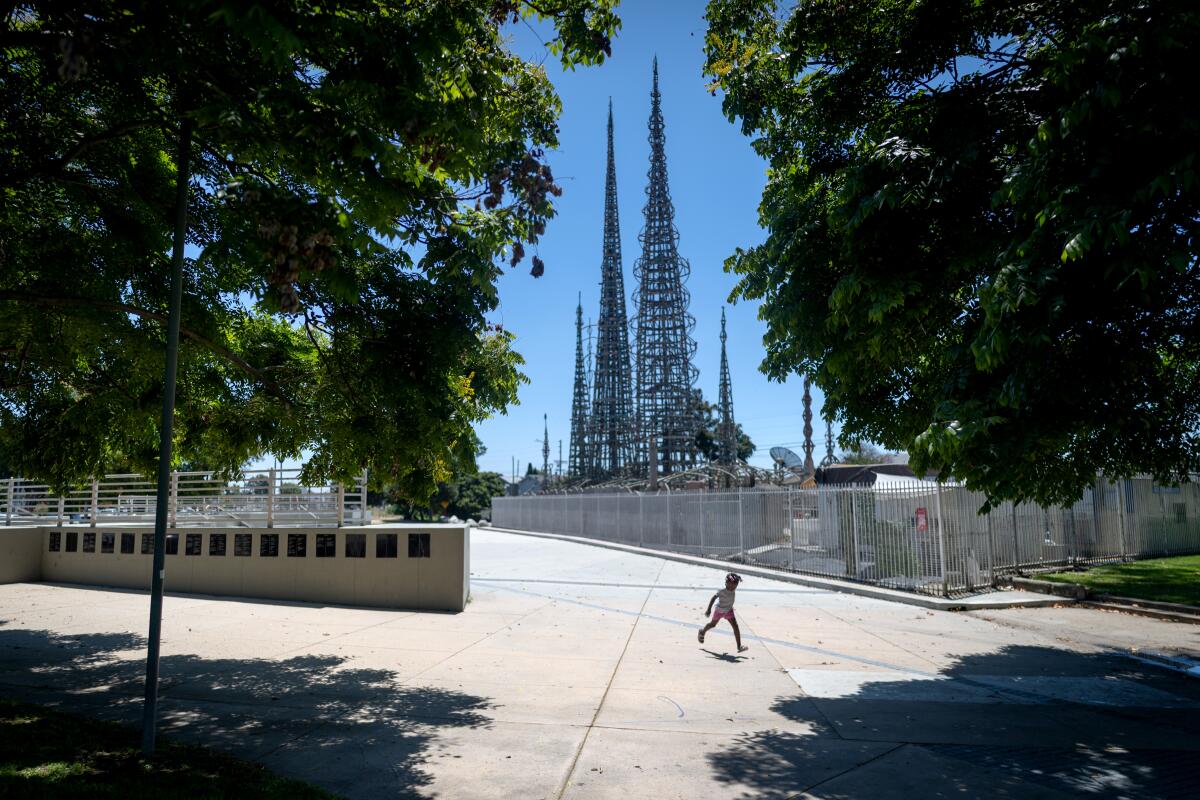 A girl plays near the Watts Towers