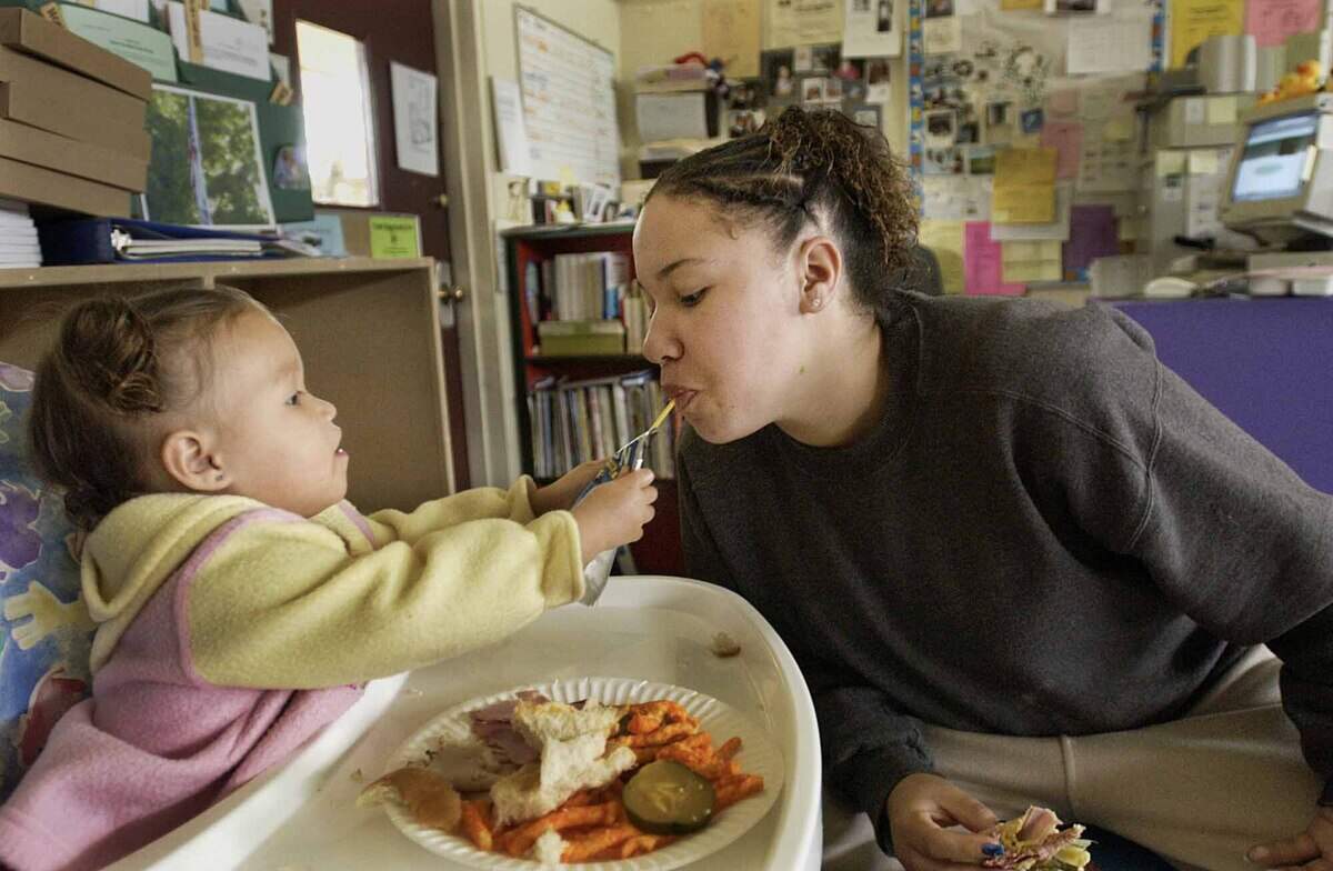 Jocelyn Wright, then 17, shares lunch with her daughter at the on-campus infant center at Adelante High School in Roseville in 2003. Jocelyn had just attended a career class and was trying to eat before her next class.