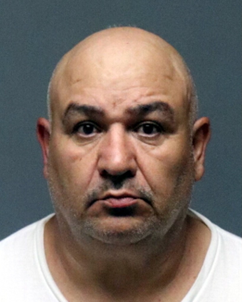 Mugshot of Cesar Flores, 55, a bald man with dark eyes and light stubble, wearing a white shirt.