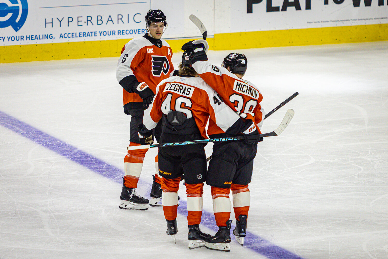 Philadelphia Flyers defenseman Travis Sanheim (6), center Trevor Zegras (46), and right wing Matvei Michkov (39) meet at center ice against the Nashville Predators at the Xfinity Mobile Arena.
