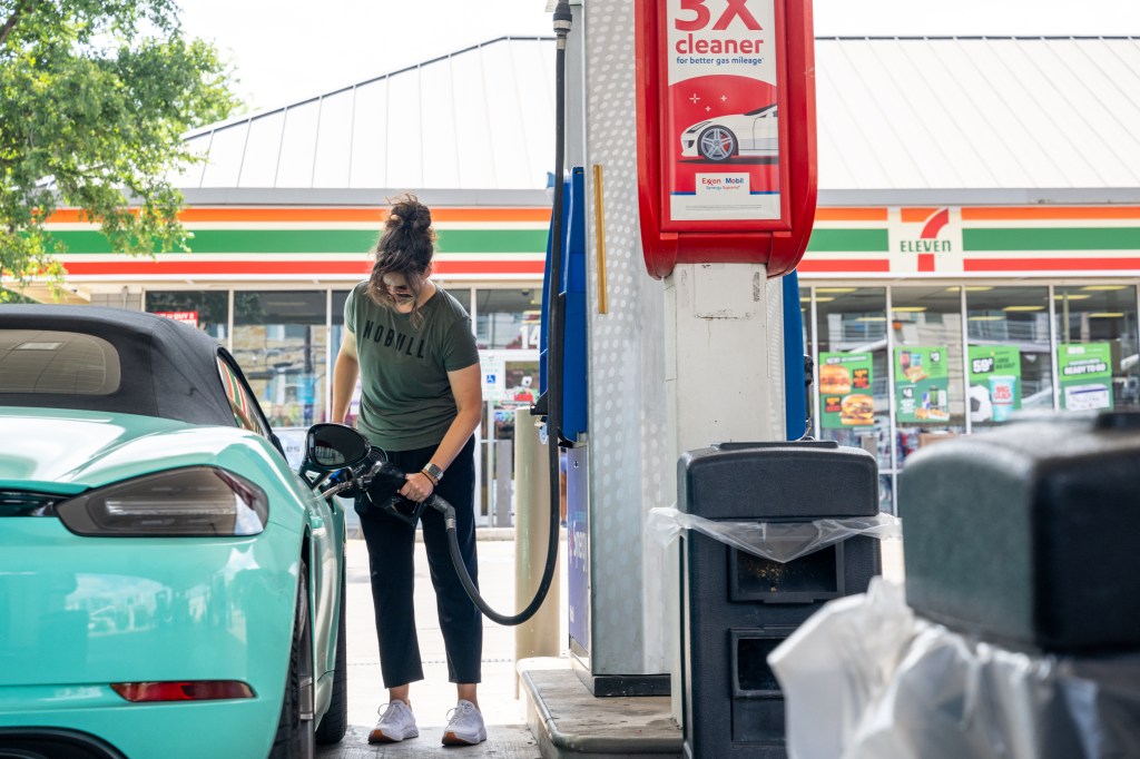 A person pumps gas into a car at a Mobil gas station.