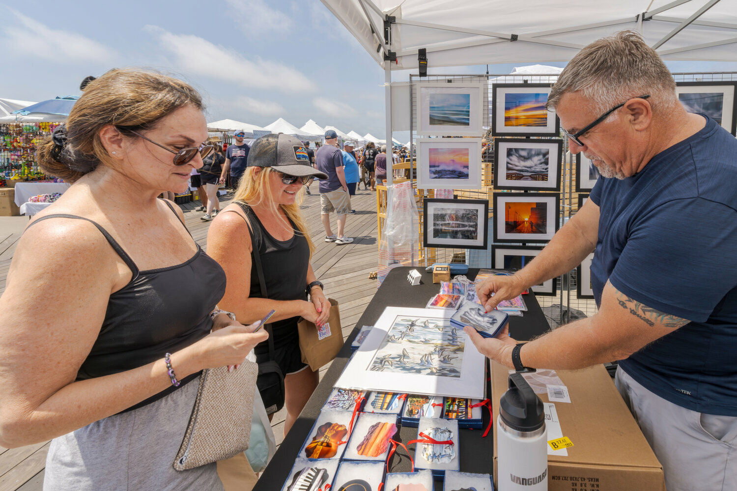 Diane Nystrom from Oceanside, left, and Stephanie Williams, of Long Beach, bought artwork from Scott Ferrone during last year&rsquo;s boardwalk fair.