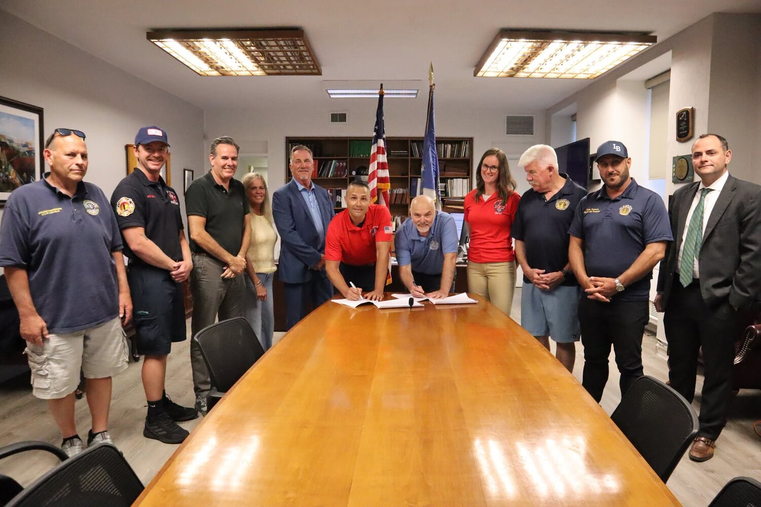 IAFF Local 287 President Sam Pinto, center left, and City Manager Daniel Creighton signed the long-awaited contract, surrounded by the City Council and members of the Long Beach Fire Department.