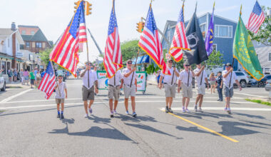 Long Beach City Councilman George Ennis, fourth from left, walked as a flagbearer with the color guard. City Council members also joined in walking the parade route.