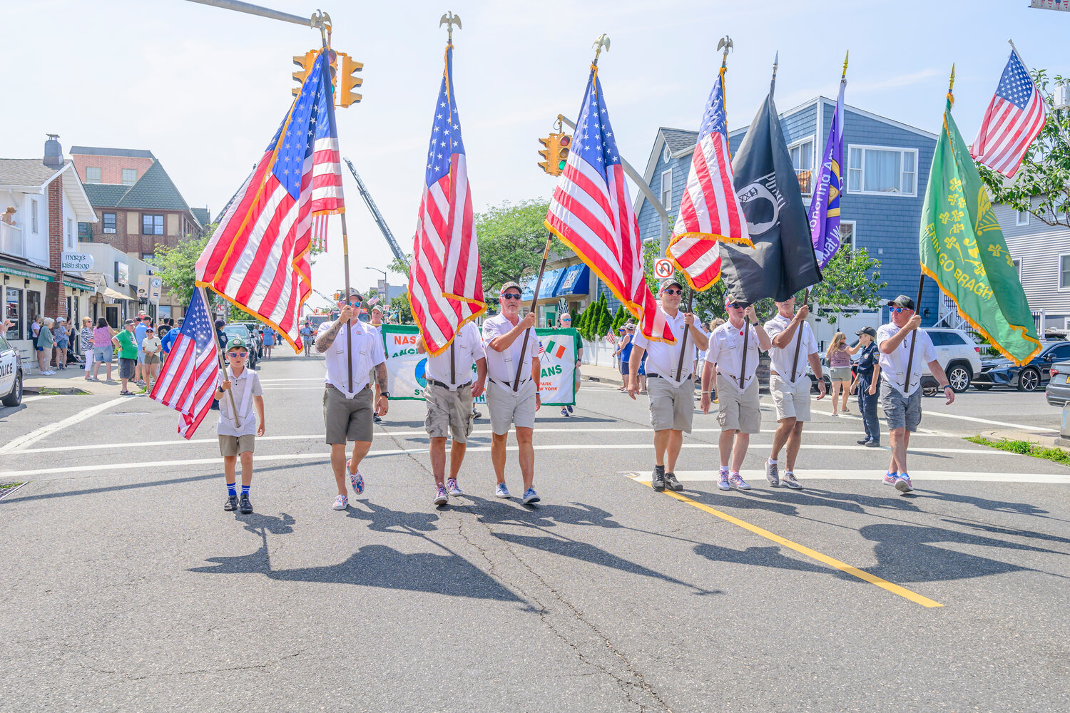 Long Beach City Councilman George Ennis, fourth from left, walked as a flagbearer with the color guard. City Council members also joined in walking the parade route.