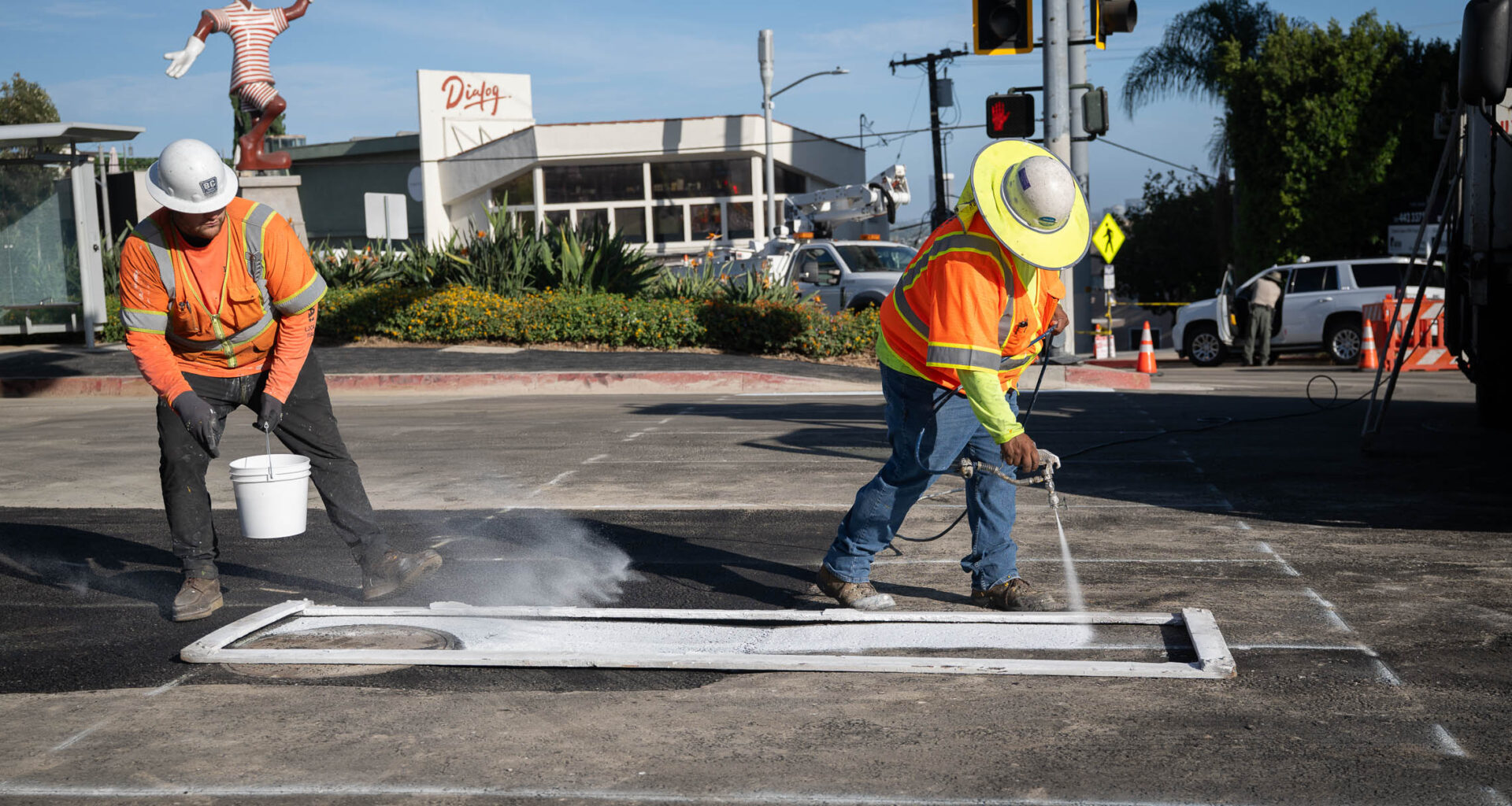 2 LADWP workers in safety gear stripe the pavement in West Hollywood.