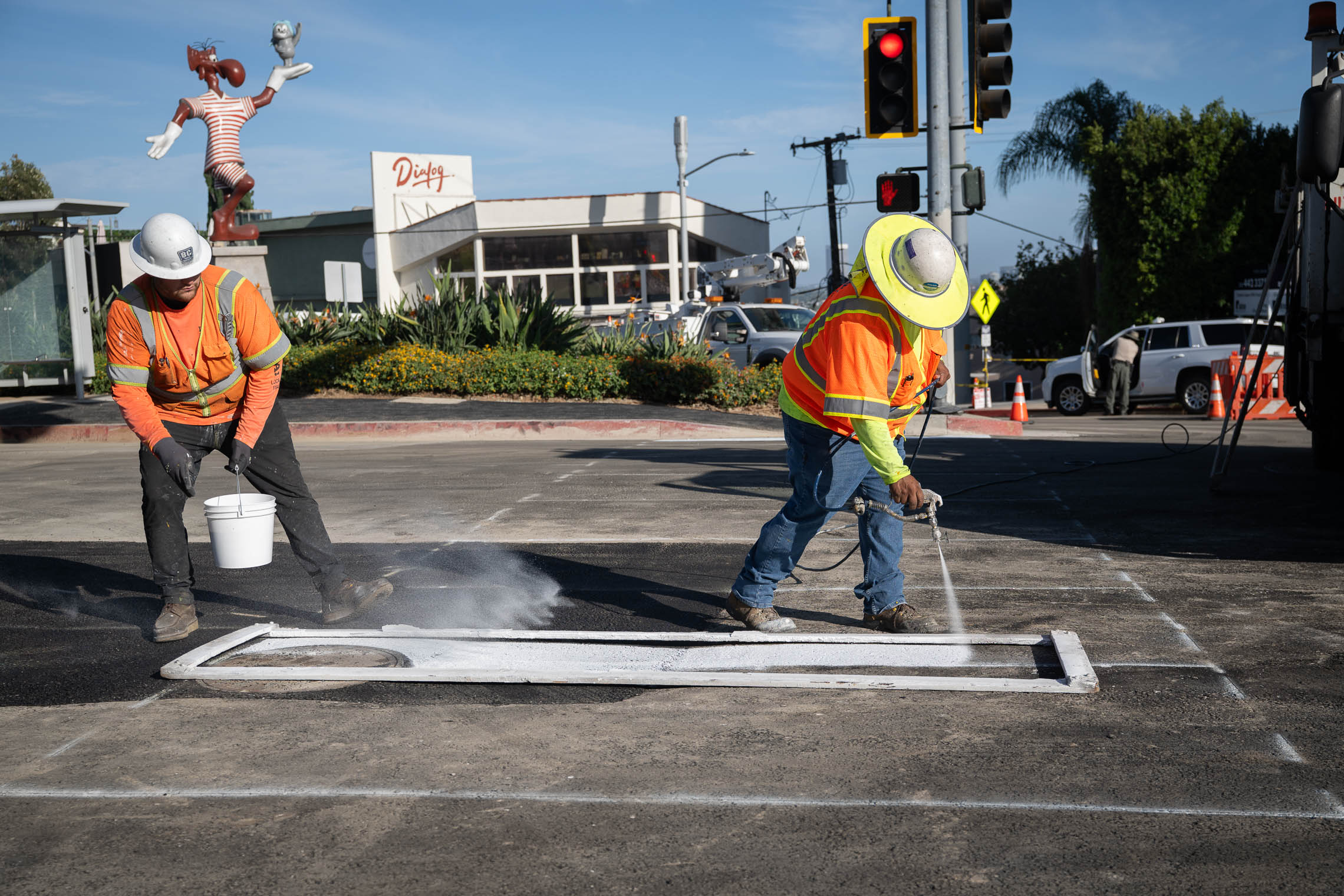 2 LADWP workers in safety gear stripe the pavement in West Hollywood.