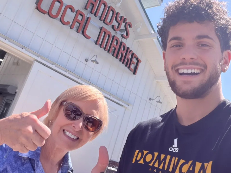 An older woman and a younger man giving a thumbs up.