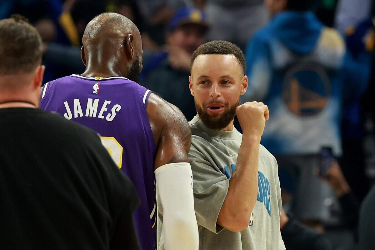 Stephen Curry of the Golden State Warriors speaks to LeBron James of the Los Angeles Lakers during a timeout of the first half April 9 at Chase Center in San Francisco.
