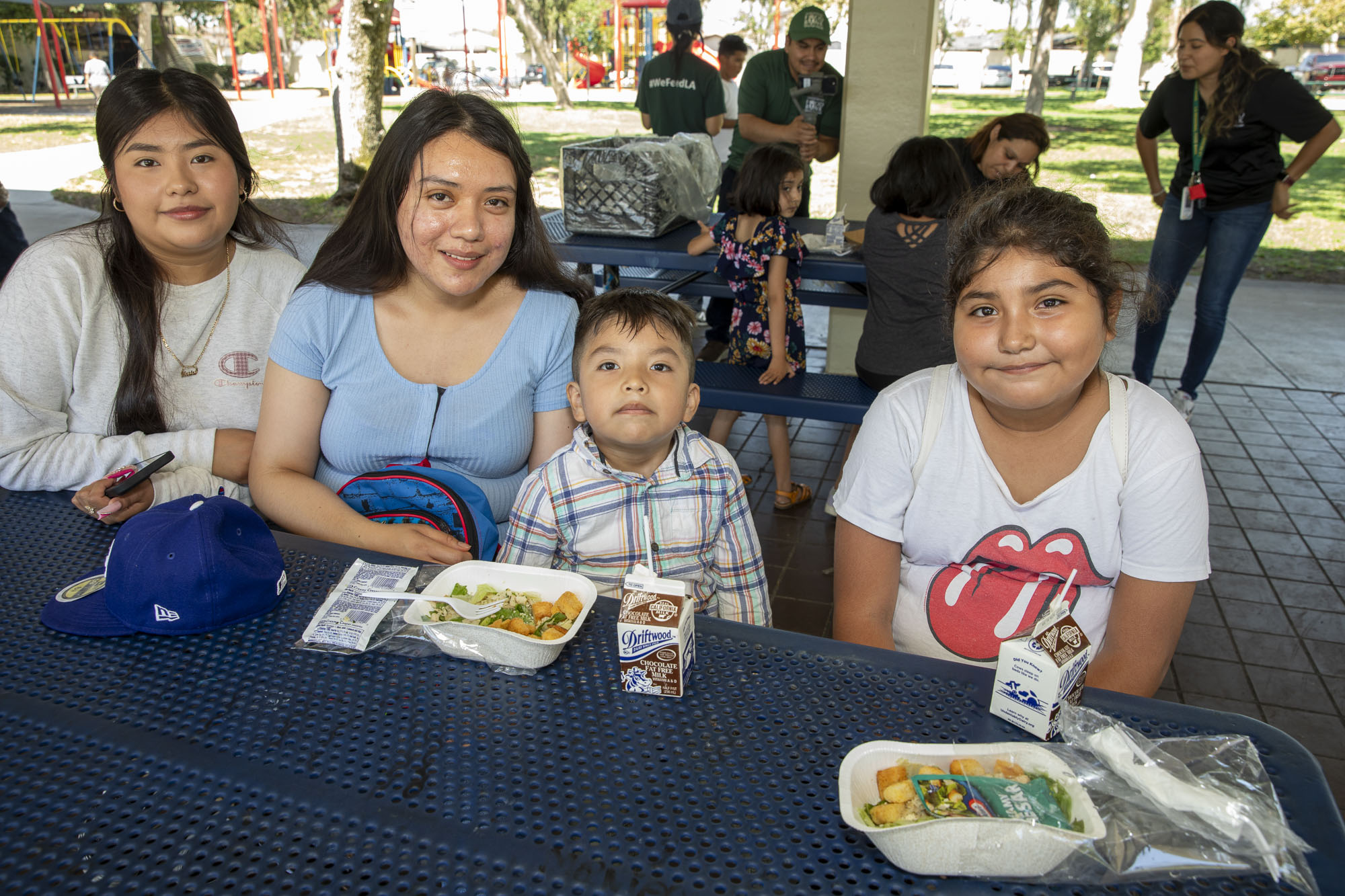 Two older adult women with their two younger siblings during a free summer meals distribution at Bristow Park during the 2023 summer