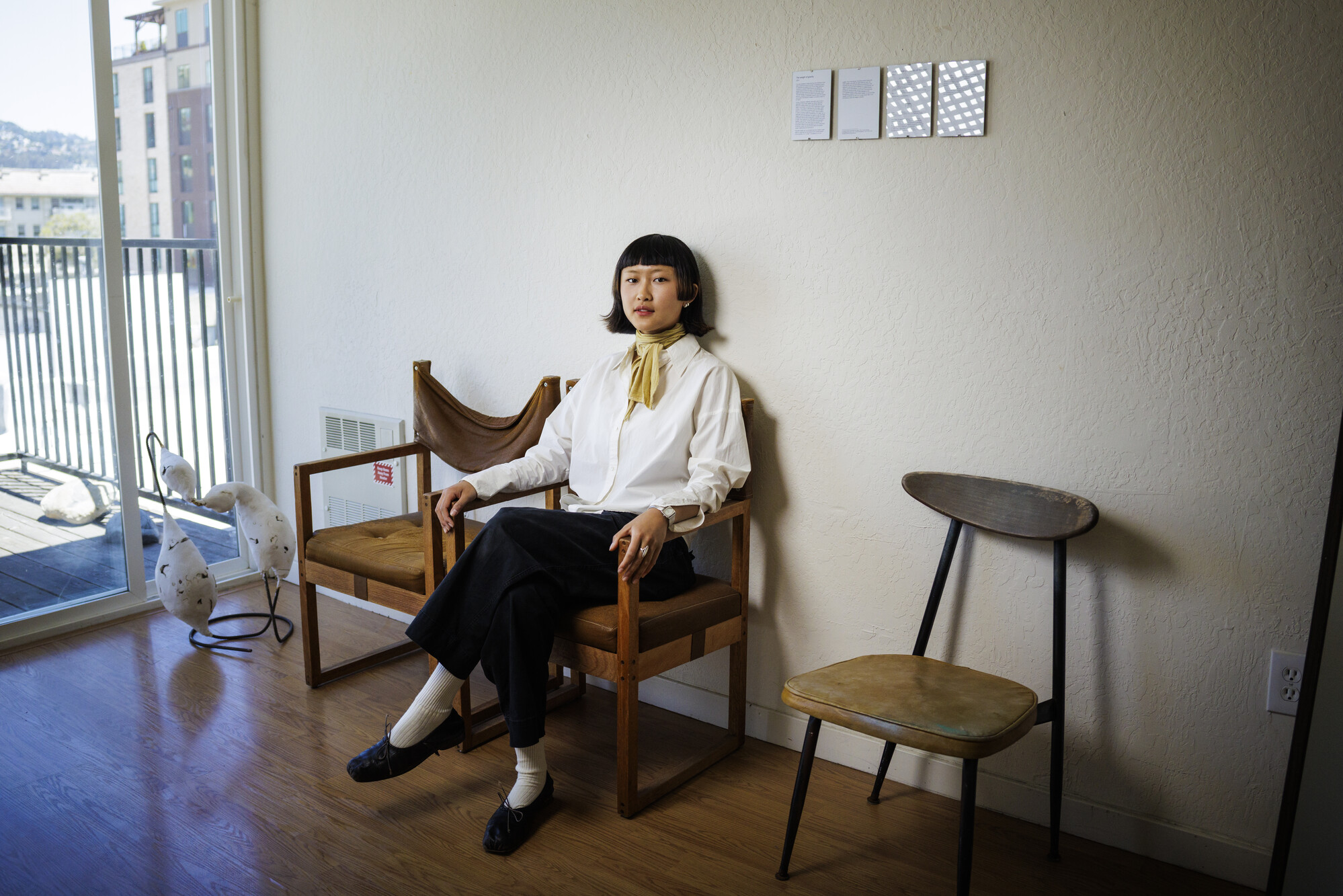 young Asian woman sits in chair in apartment
