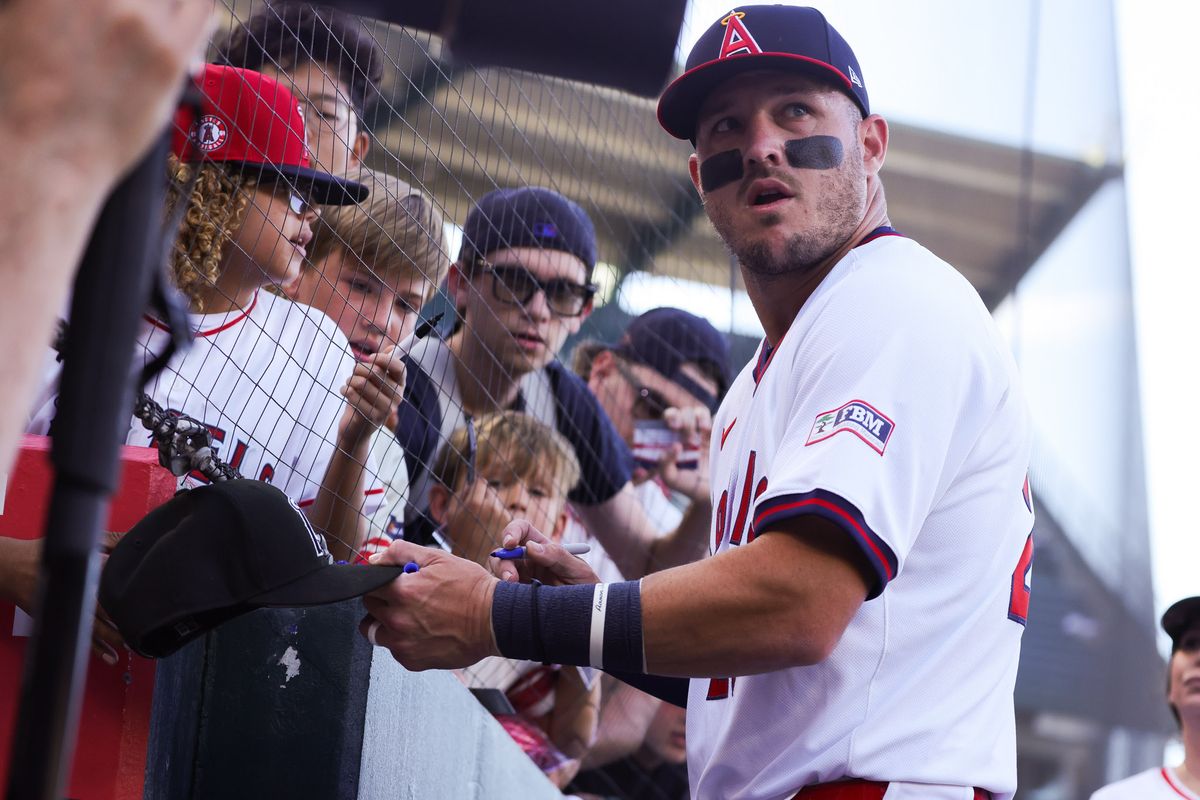 Los Angeles Angels outfielder Mike Trout (27) signs a hat for a young fan before the MLB game against the Detroit Tigers Friday July 17th, 2026 at Angel Stadium in Anaheim, Calif.