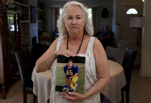 Christina McGinty displays a photograph of her son Robert Austin, Saturday, May 10, 2025, when he was football player at Cloverdale High School. He was addicted to opioids and was homeless in recent years. Robert, 43, died after he overdosed at Orenda Center in Santa Rosa on March 14. (Kent Porter / The Press Democrat)