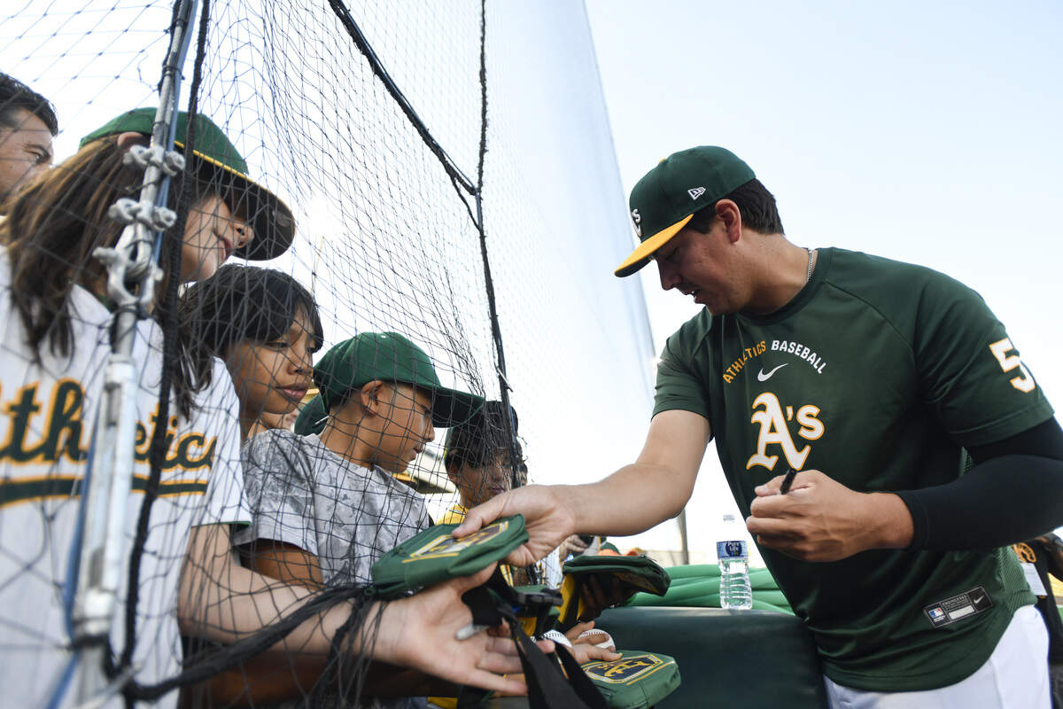 Athletics pitcher Jacob Lopez (57) signs autographs for fans before a game against the Washington Nationals at Sutter Health Park in West Sacramento on Friday, July 17, 2026.