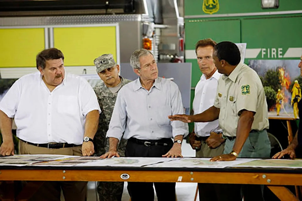 President George W. Bush (center) and California Governor Arnold Schwarzenegger (second from right) are briefed by U.S. Forest Service Regional Forester Randy Moore (right) on July 17, 2008. Bush visited Redding to survey the wildfire damage in the North State.