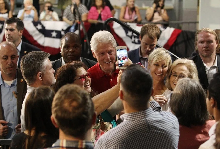 A woman takes a picture with President Bill Clinton as Redding City Council members Brent Weaver, center, and Kristen Schreder, right, and Chuck Aukland, left, also take pictures of Clinton after he spoke Thursday, June 2, 2016 at Shasta College, campaigning for his wife, Hillary Clinton, for the upcoming primary election.
