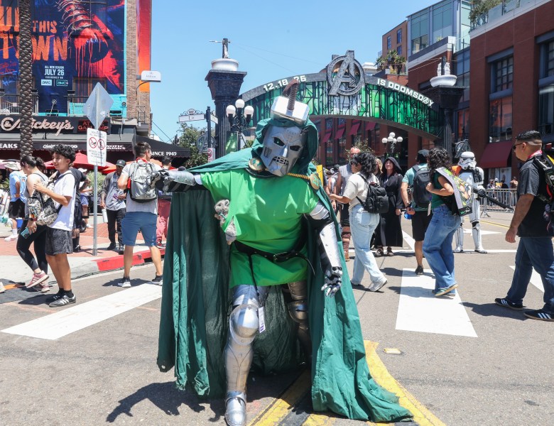 person in armor and green cloak with hammer in head
