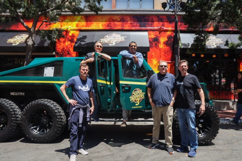 five dudes in front of a humvee like vehicle