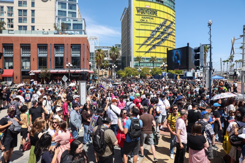 Crowd with a building wrapped in Wolverine ads behind them