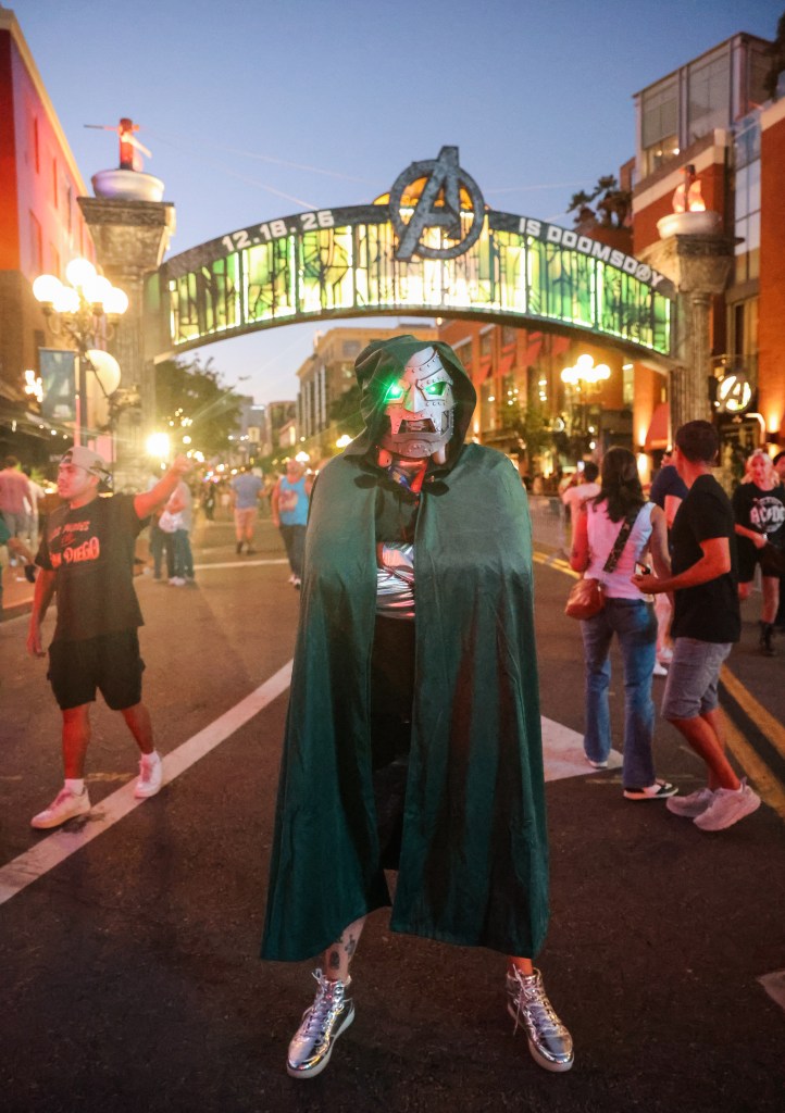 Person with metal mask, glowing green eyes, green cloak.