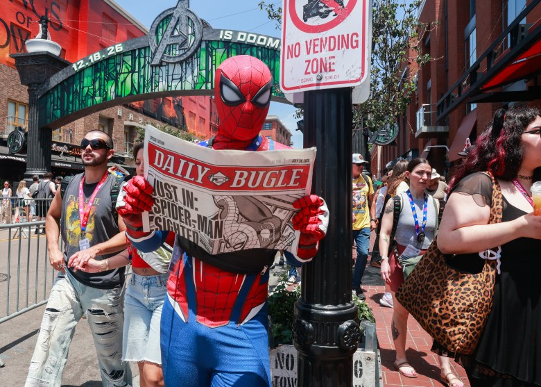 Spiderman reads a newspaper