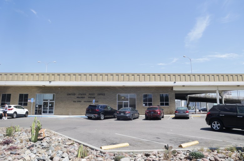 front of. a building with parking options and cacti