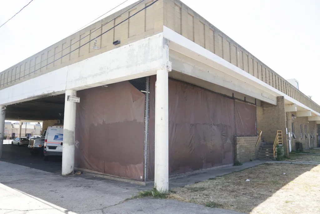 The corner of a building covered by tarps.