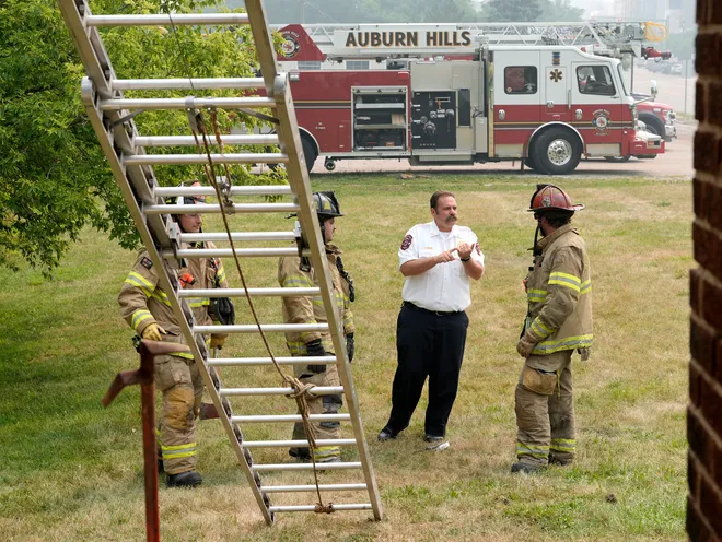 Auburn Hills Fire Department Chief Trevin Robinson talks with three firefighters during a training at a house on Auburn Road in Auburn Hills on Thursday, July 16, 2026.